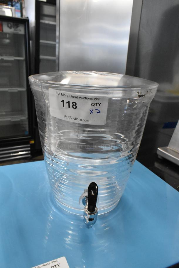 Clear poly beverage dispensers, brand new scratch and dent, show cracks. Includes two units, item tag indicates "118, QTY x2".