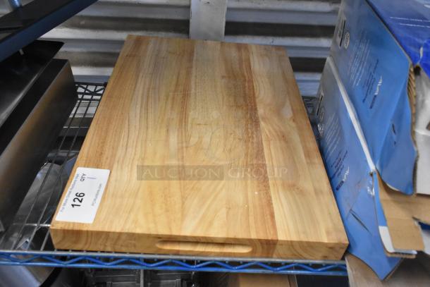 Brand new wooden cutting board, scratch and dent condition, rectangular with handle cutout, natural wood grain finish.
