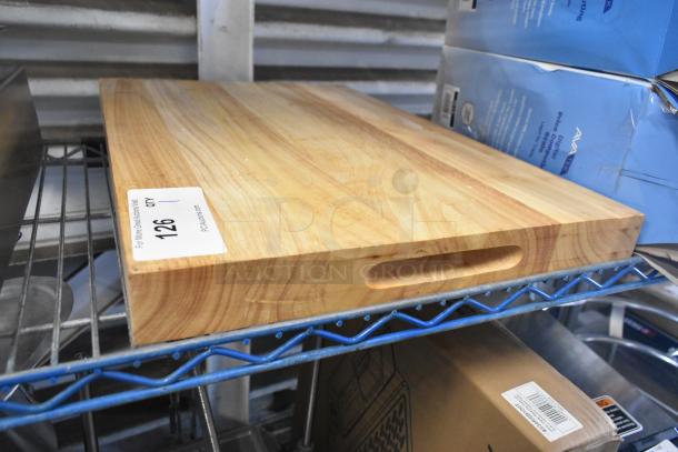 Brand new scratch and dent wooden cutting board with handle groove. Slight surface imperfections. Auction tag number 126 visible.