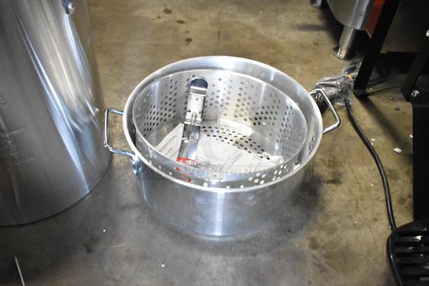 Brand new Backyard Pro metal fryer pot, scratch and dent, includes handles and perforated basket, on concrete surface.