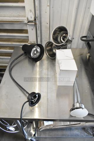 Two brand new CK2514E008 and CK2510D237 metal heat lamps, scratch and dent condition, on a metal surface.