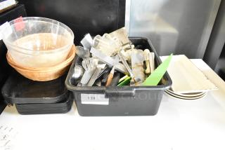 Assorted lot of utensils, trays, bus bin, and bowls. Includes metal and plastic items. Condition varies, some wear visible.