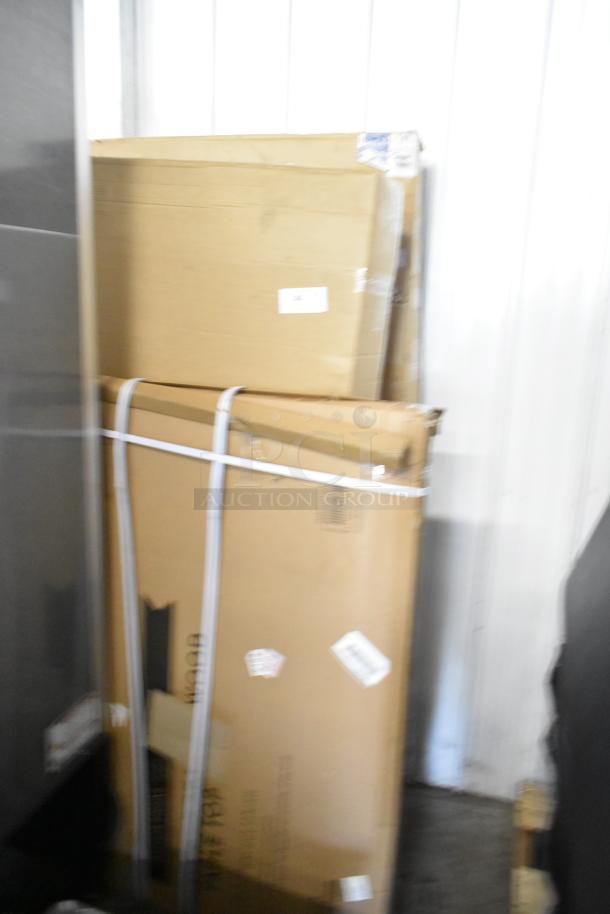 Three brand new boxes, including Tabletop and ECE Cafe Loft Box, stacked in a storage area.