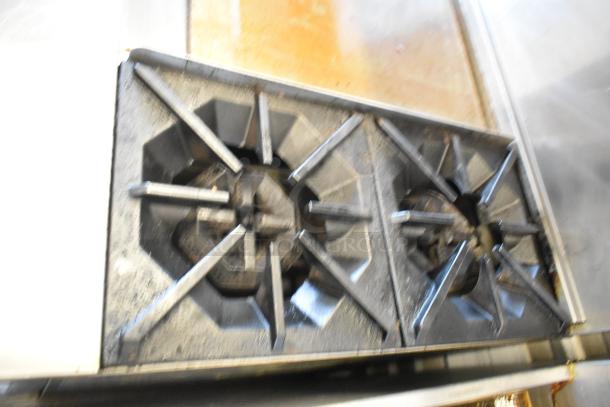 Cook Rite ATO-48G2B stainless steel range with 2 burners, showing heavy use. Part of a commercial griddle setup.