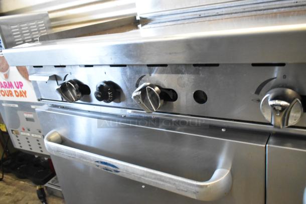 Cook Rite ATO-48G2B stainless steel commercial gas flat top griddle, 2 burners, ovens, shelf, back splash, on casters.