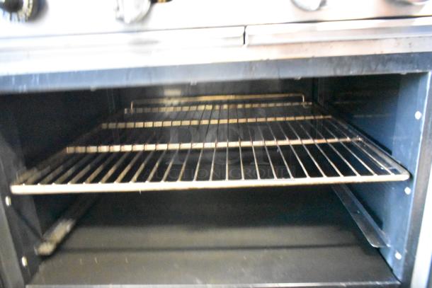 Cook Rite ATO-48G2B oven interior with metal racks, part of a stainless steel griddle unit, showing used condition.