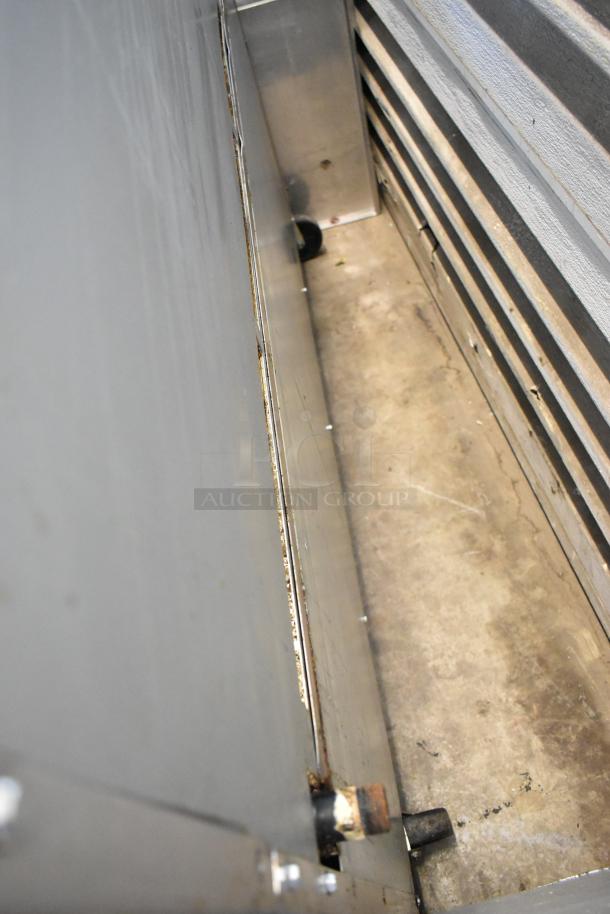 Interior view of the Cook Rite ATO-48G2B stainless steel commercial griddle setup with casters. Image shows panel and backing detail.