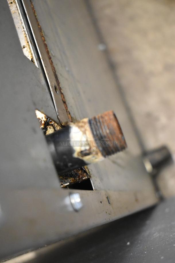 Close-up view of a pipe and metal surface on the Cook Rite ATO-48G2B stainless steel commercial gas griddle, showing rust and wear.