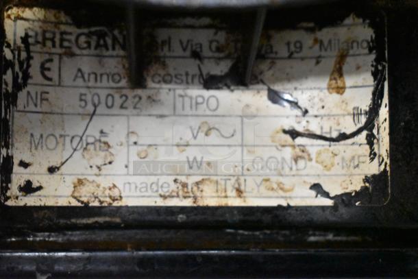 Close-up of Bregani espresso grinder label, showing model NF 50022, made in Italy. Label is stained and worn.