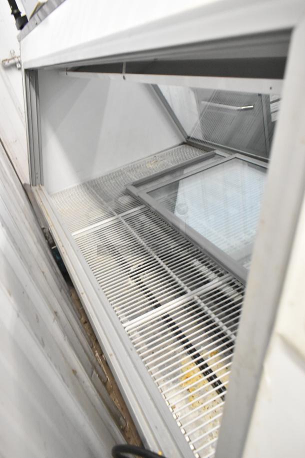 McCray Metal Commercial Deli Display Case, floor style, 115 volts, 1 phase. Features glass panels, metal shelving.