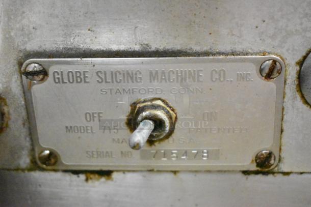Globe 715 metal commercial meat slicer with blade sharpener, 115 volts, 1 phase, serial number 715478, shows manufacturer's label.