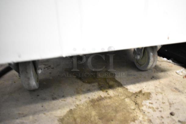 Alpine OP238EC soft serve ice cream machine on caster wheels, white metal exterior, visible floor stains below.