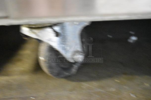 Blurred close-up of a commercial caster wheel on the 2019 Atosa MCF8570GR freezer.