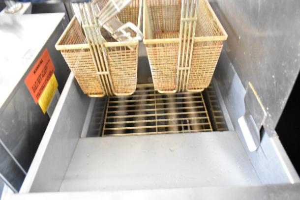 2017 Pitco SG14 stainless steel gas fryer with two metal baskets, side splash guard, visible warning label.