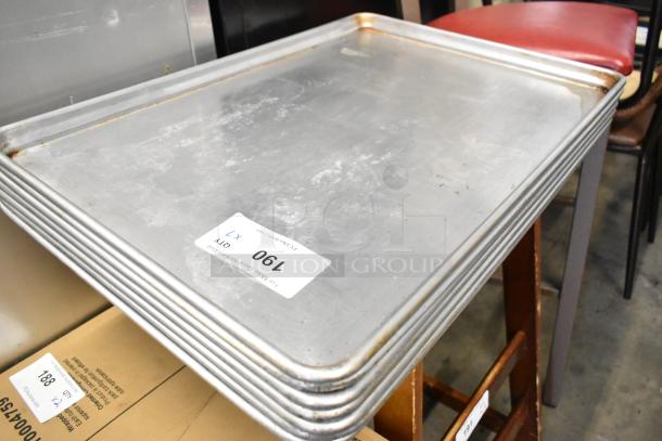 Seven metal full-size baking pans stacked, showing moderate wear. Auction tag "190."
