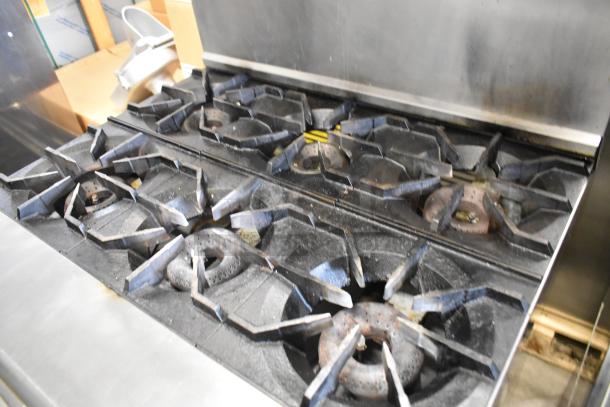 American Range stainless steel commercial gas 6-burner range, featuring oven, overshelf, and backsplash, in used condition.