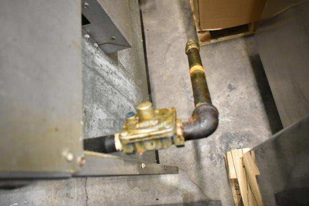 Alt Text: Close-up of a gas line connection for an American Range commercial 6 burner oven, showing steel and brass components.