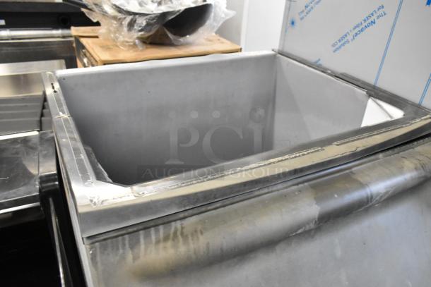 Metal commercial ice bin with stainless steel finish, open lid, minor surface wear, suitable for restaurant use.