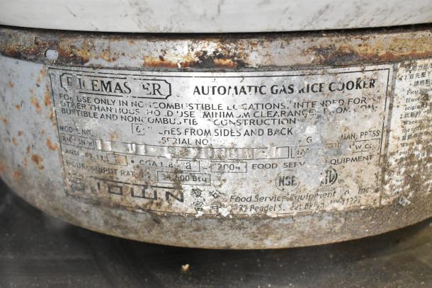 RiceMaster Automatic Gas Rice Cooker label, showing model info, use instructions, and specifications, visible wear.