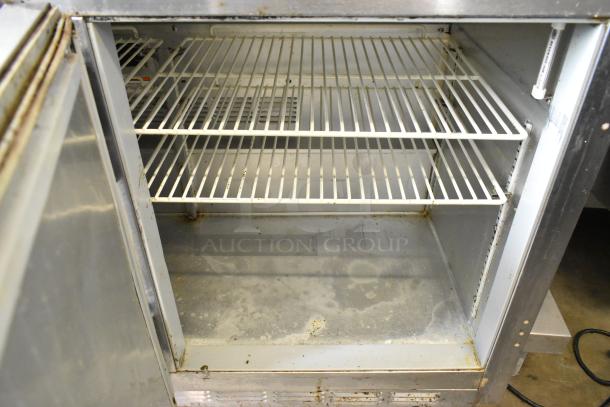 Beverage Air UCR48A stainless steel 2-door undercounter cooler on commercial casters. Visible interior shelving, slight wear.