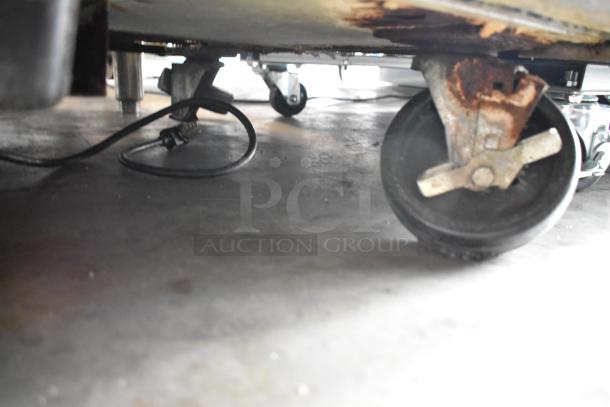 2016 True TWT-36 cooler underside showing commercial casters, plug, and signs of rust. 115V, 1 Phase, stainless steel.