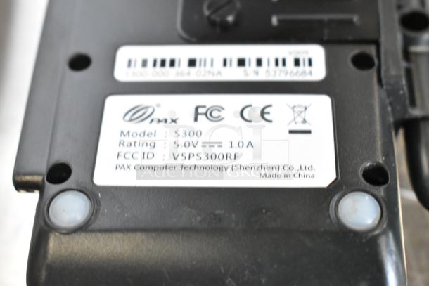 Close-up of a PAX S300 credit card reader label showing model, ratings, FCC ID, and manufacturer details.