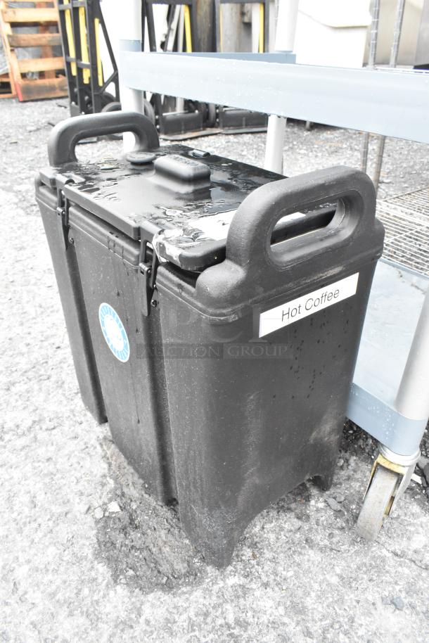 Cambro poly insulated beverage dispenser, black, labeled "Hot Coffee," with sturdy handles and secure latch, used condition.