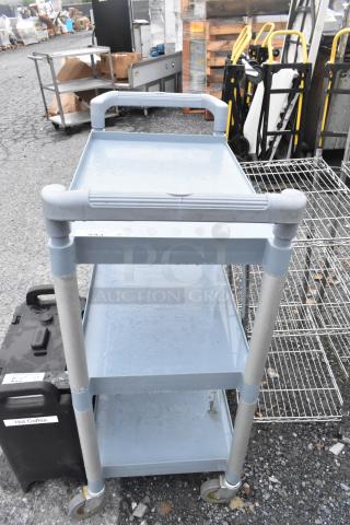 Poly blue and gray 3-tier cart on commercial casters, sturdy build, slight wear. Ideal for office or industrial use.