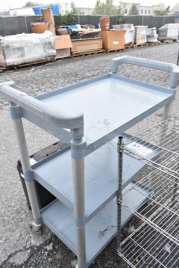 Poly blue and gray 3-tier cart with commercial casters, used condition, sturdy handles, ideal for industrial use.