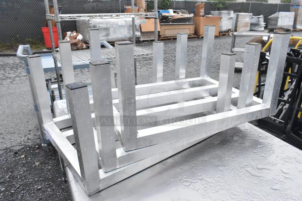 Three metal dunnage racks stacked, showing sturdy rectangular frames, slight wear, ideal for heavy-duty storage.