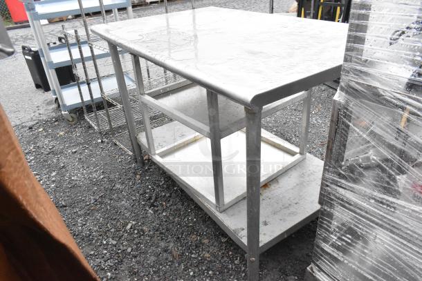 Stainless steel table with under shelf and equipment stand in used condition, suitable for commercial kitchen use.