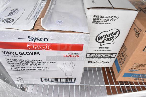 Chrome finish 4-tier wire shelving unit with contents including boxes of Sysco gloves and White Cap baking spray. Buyer must dismantle.