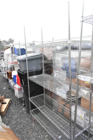Chrome finish 4 tier wire shelving unit, undismantled, outdoor setting. Buyer must dismantle. Consider freight charges.