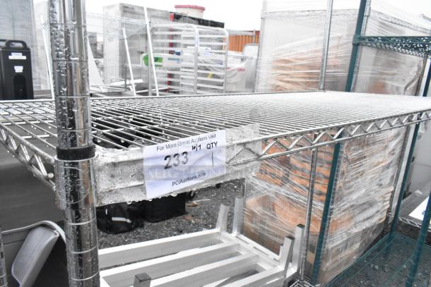 Chrome finish 3 tier wire shelving unit, wet with rain, tag showing "233" from PCI Auctions, items stacked nearby.
