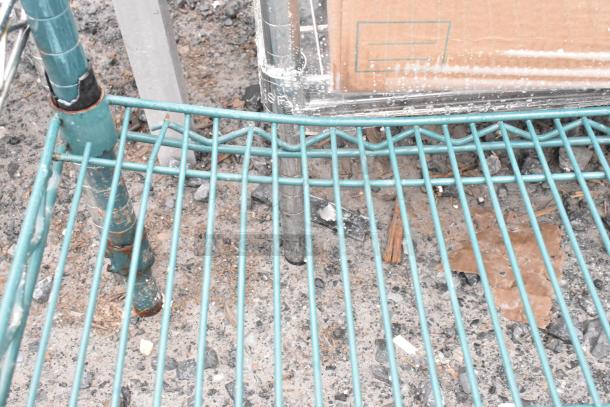 Green finish 2-tier wire shelving unit, lightly rusted. Buyer must dismantle. Consider freight charges.