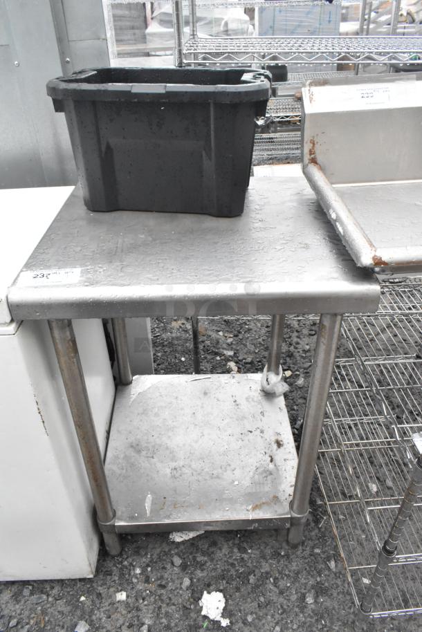 Stainless steel table with under shelf, used condition, surface wear visible, sturdy construction, ideal for kitchen use.