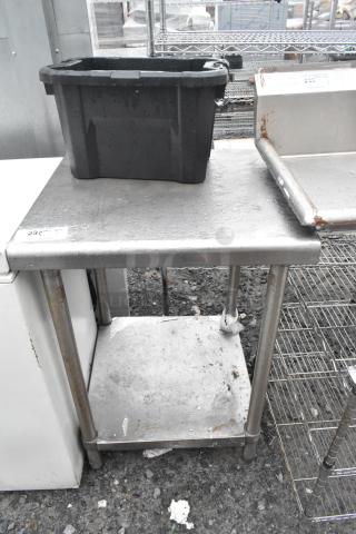 Stainless steel table with under shelf, used condition, surface wear visible, sturdy construction, ideal for kitchen use.