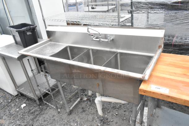 Stainless steel 3 bay sink with left side drain board, faucet, and handles. Features durable construction and good condition.