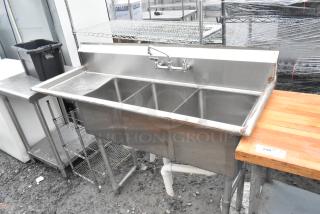 Stainless steel 3 bay sink with left side drain board, faucet, and handles. Features durable construction and good condition.