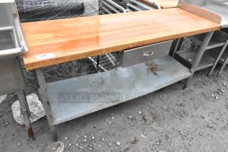 Butcher block table with wooden top, metal drawer, and under shelf. Visible wear and rust on metal parts. Item tag: "240."