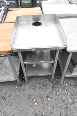 Stainless steel table with two undershelves, integrated backsplash, and drain hole. Used condition. Label reads "241".