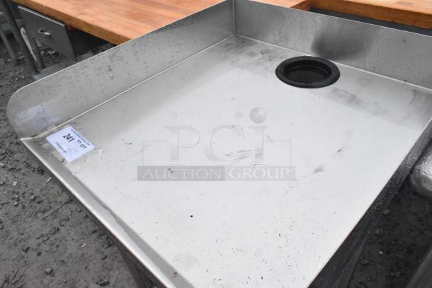 Stainless steel table with 2 under shelves, used condition, visible wear. Includes drainage hole and item tag labeled "241."