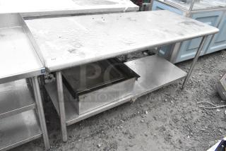 Stainless steel table with an under shelf and visible wear, shown outdoors. ID tag indicates item "242."