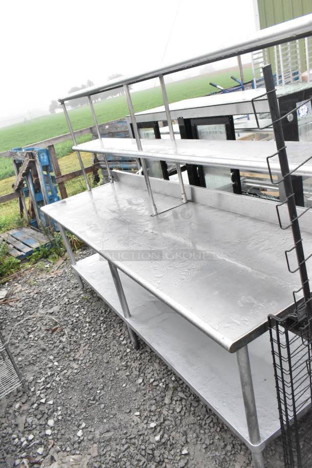 Stainless steel table with under shelf and two-tier over shelf, in good condition, outdoors, wet surface.