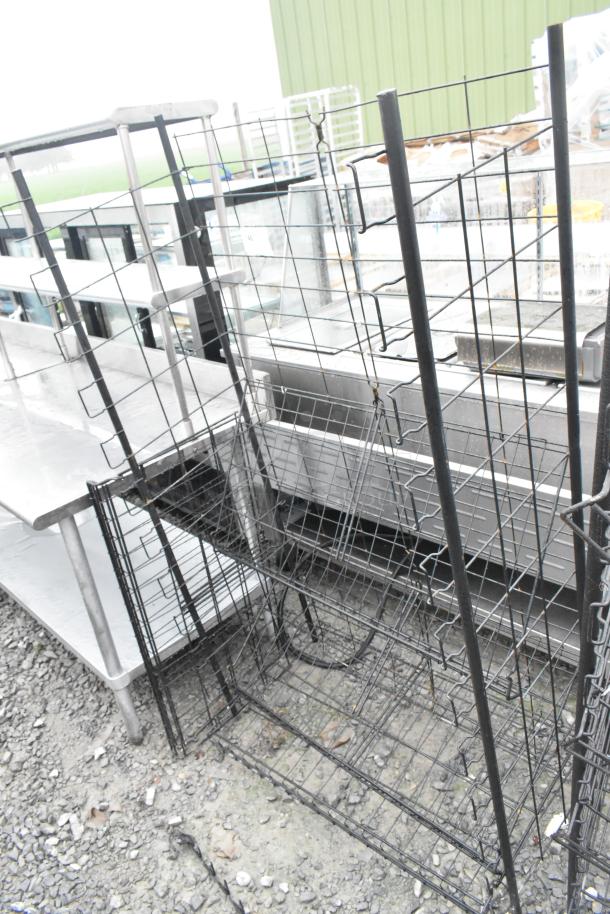 Two black wire shelving units, sturdy metal construction, outdoor setting, used condition, no visible labels or tags.