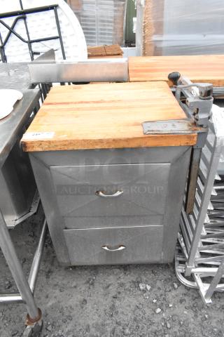 Metal commercial counter with a butcher block countertop, mounted commercial can opener, and two drawers. Visible wear.