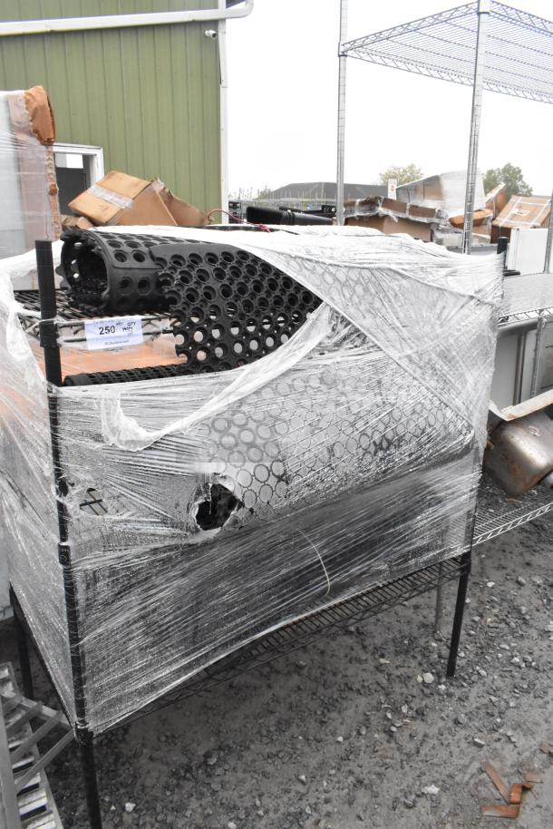 Black finish 3-tier wire shelving unit with contents and floor mat, wrapped in plastic, buyer must dismantle.