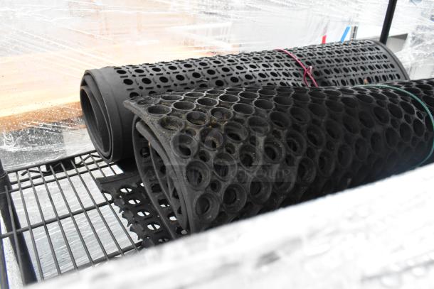 Black 3-tier wire shelving unit with multiple floor mats; dismantling and freight considerations required for shipping.
