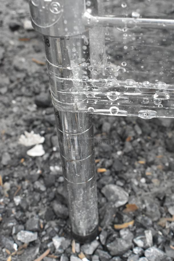 Chrome finish 4-tier wire shelving unit leg with baskets, shown with water droplets. Surface details visible.
