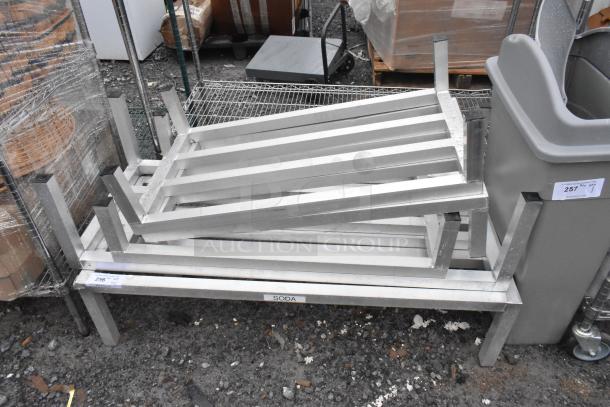 5 metal dunnage racks stacked, silver finish, sturdy condition, labeled "SODA." Auction with 5 times your bid offer.